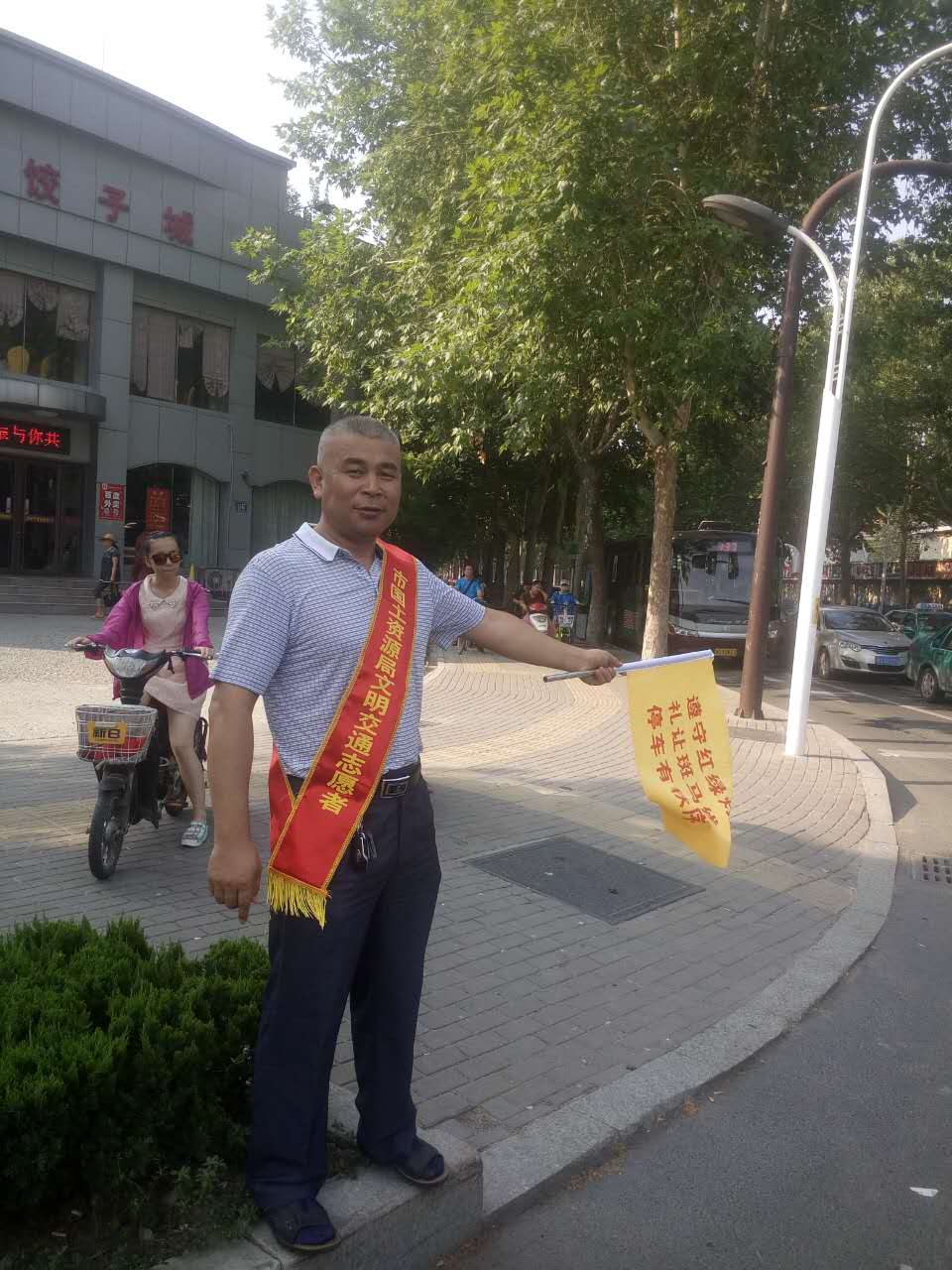 人民路与西五楼路口,日博体育文明交通志愿者疏导交通,宣传文明出行。