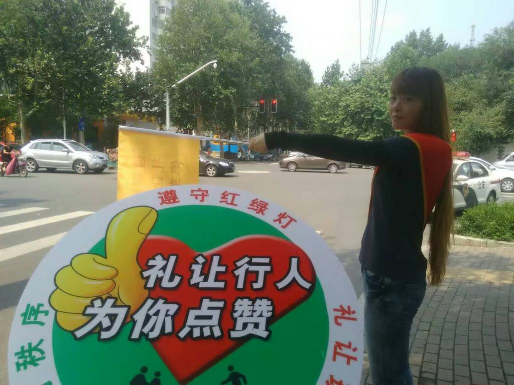 人民路与西五楼路口,日博体育文明交通志愿者疏导交通,宣传文明出行。